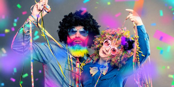 Homme et femme heureux portant des perruques de couleur avec des articles de fête
 - Photo, image