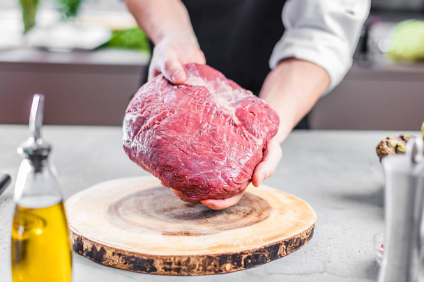Chef in restaurant kitchen cooking,he is cutting meat or steak  - Φωτογραφία, εικόνα