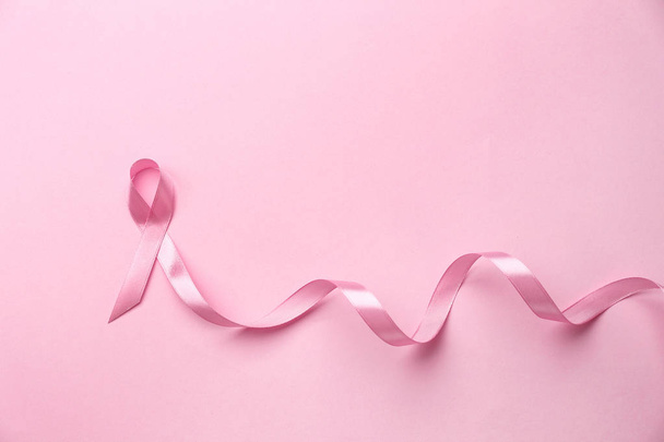 Pink ribbon on color background. Breast cancer concept - Photo, Image