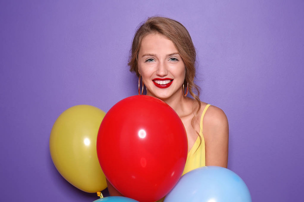 Krásná mladá žena s balónky na barevném pozadí - Fotografie, Obrázek