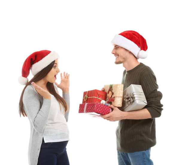 Młoda kobieta odbiera prezenty świąteczne z jej mąż na białym tle - Zdjęcie, obraz