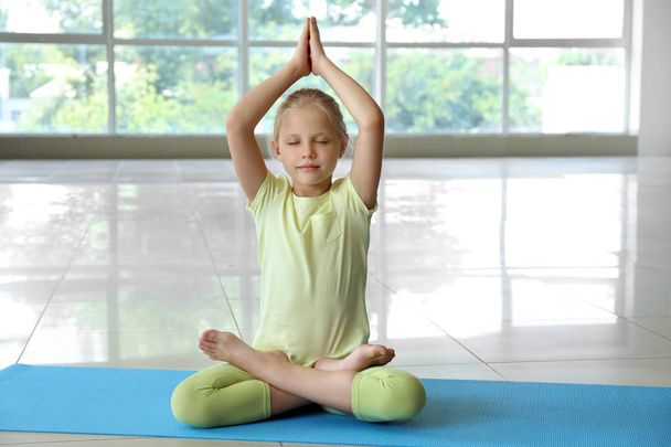 Petite fille pratiquant le yoga à l'intérieur
 - Photo, image