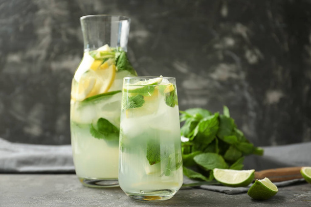 Glass and jug of fresh mojito on grey table - Foto, Imagen