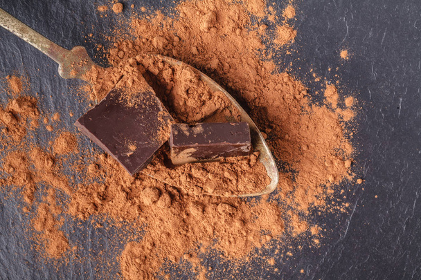 Cocoa powder and chocolate in spoon on slate - Valokuva, kuva