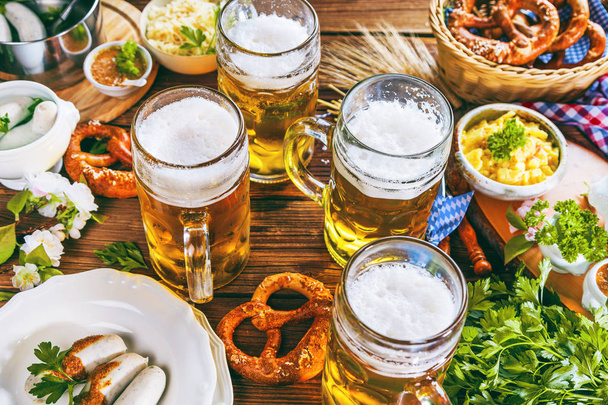 Oktoberfest beer, pretzels and various Bavarian specialties on wooden background - Fotografie, Obrázek