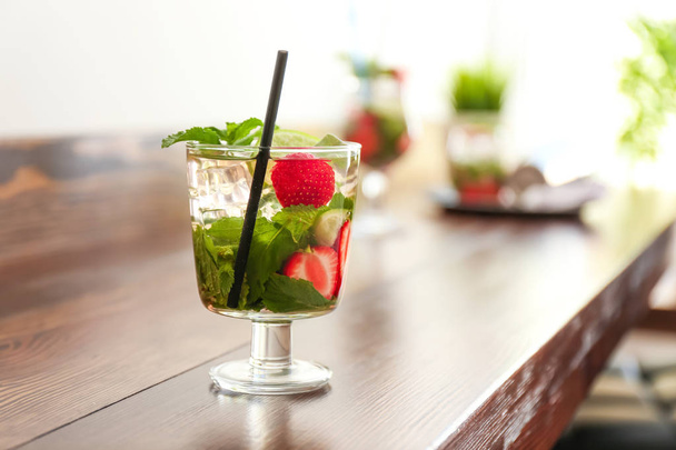 Glass of fresh strawberry mojito on wooden table - Foto, Imagen