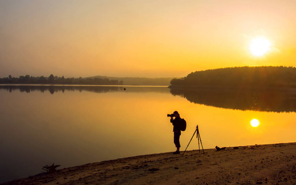 Photographe prenant des photos du lac au coucher du soleil
 - Photo, image