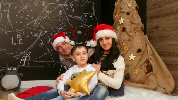 Familie posiert in Weihnachtsmützen vor der Kamera - Filmmaterial, Video