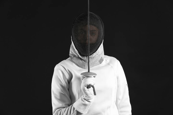 Young female fencer on dark background - Photo, Image