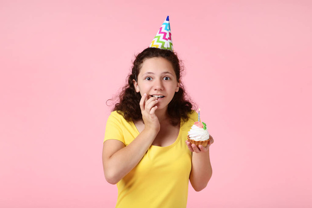 Beautiful young girl with cupcake on pink background - Fotó, kép
