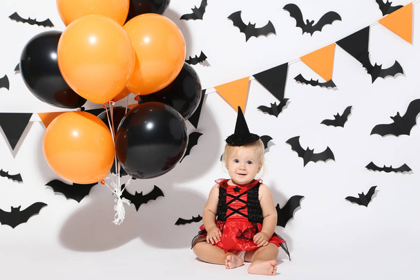 Baby girl in halloween costume and balloons on white background - Φωτογραφία, εικόνα