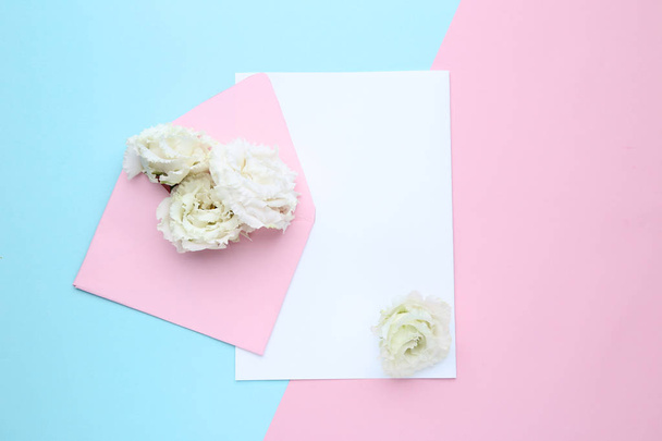 White eustoma flowers with envelope and sheet of paper on colorful background - Valokuva, kuva