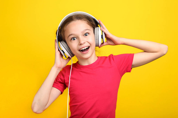 Young girl with headphones on yellow background - Foto, Imagem