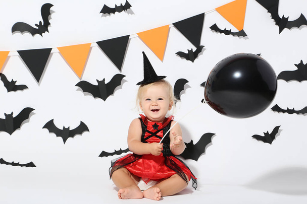 Baby girl in halloween costume and balloon on white background - Foto, afbeelding
