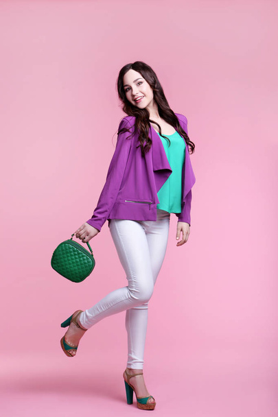 Beautiful young woman with handbag on pink background - Foto, Imagen