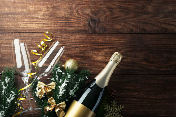 Champagne bottle with glasses and fir-tree branches on brown wooden table - Foto, immagini