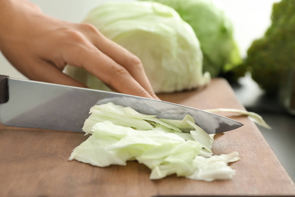 Woman cutting fresh cabbage, closeup - Фото, изображение