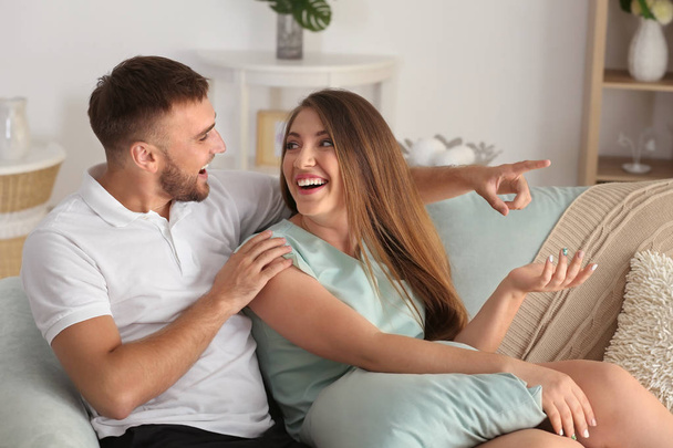 glückliches junges Paar ruht sich zu Hause auf dem Sofa aus - Foto, Bild