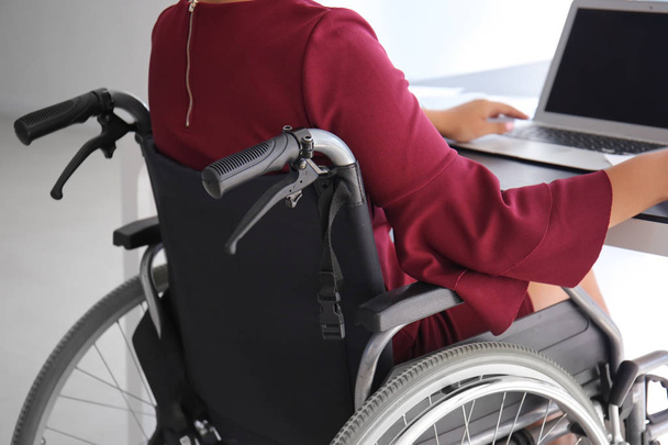Asyalı kadın ofiste dizüstü bilgisayar ile çalışan tekerlekli sandalyede - Fotoğraf, Görsel