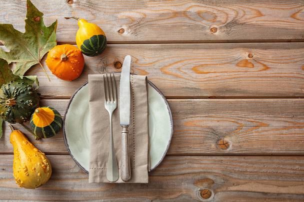 Concept de Thanksgiving. Citrouilles colorées et mise en place sur une table en bois rustique, espace de copie, vue sur le dessus
 - Photo, image