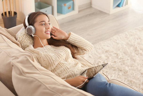 Krásná mladá žena poslouchá hudbu doma - Fotografie, Obrázek