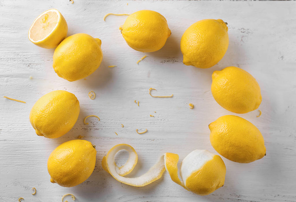 Frame made of ripe lemons on white wooden background - Photo, Image