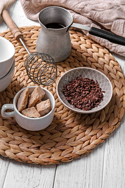Cezve de chocolat chaud avec des ingrédients sur tapis en osier
 - Photo, image