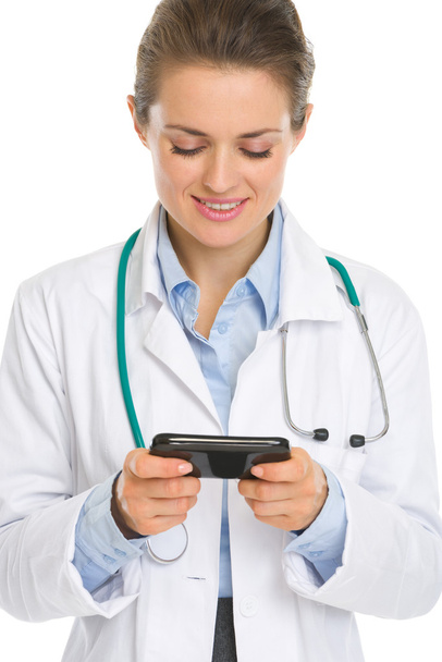 Smiling medical doctor woman reading sms - Fotoğraf, Görsel