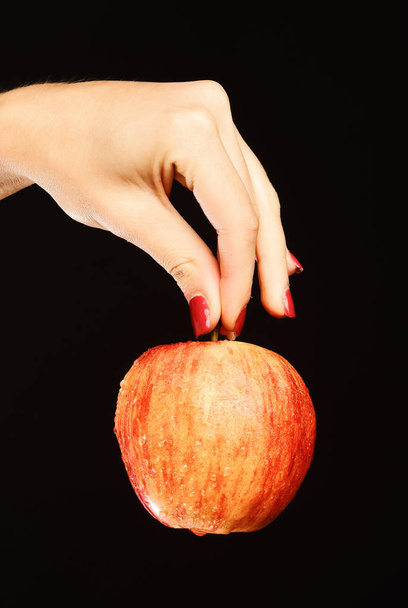 Apple in red and orange color in girls fingers. - Foto, Imagen
