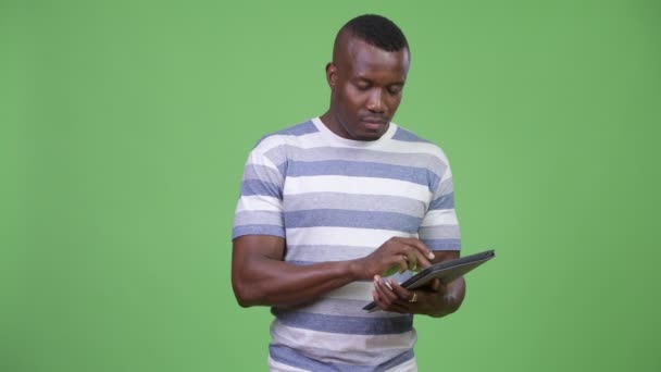 Young African man thinking while using digital tablet - Video, Çekim