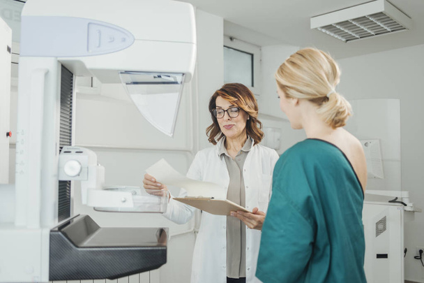 Woman oncologist talking with her patient on mammography examination. - Zdjęcie, obraz