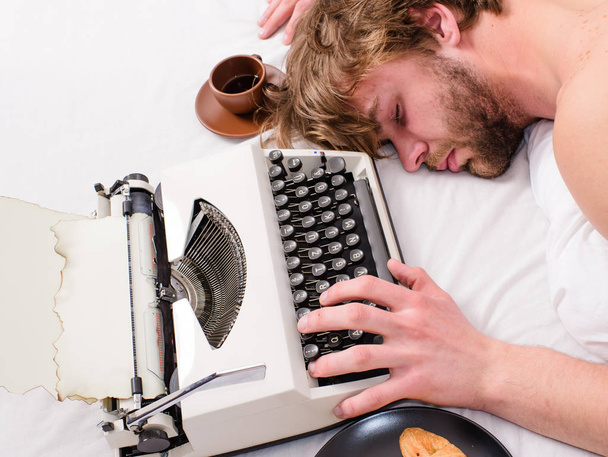 Schriftsteller verwendete altmodische Schreibmaschine. Autor zerzauste Haare schlafen ein, während er Buch schreibt. Workaholic schläft ein. Mann mit Schreibmaschinenschlaf. Anstrengende Beschäftigung. Mann lag während der Arbeit schlafend in Bettwäsche - Foto, Bild