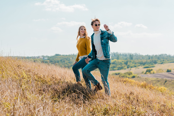 attractive couple walking on rural meadow - Fotoğraf, Görsel