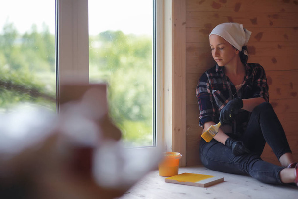 Femme avec brosse de réparation dans une maison en bois
 - Photo, image