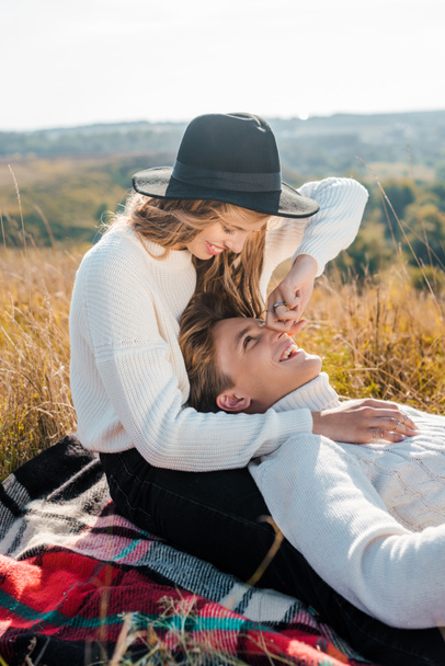 草原で彼氏の鼻に触れる若いガール フレンド - 写真・画像