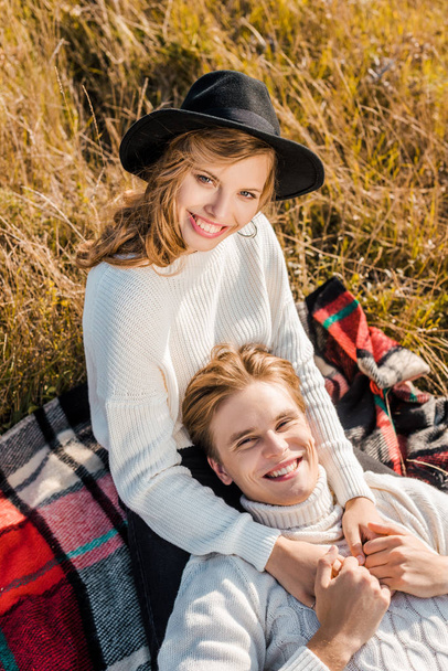 happy young couple looking at camera on rural meadow - Фото, изображение