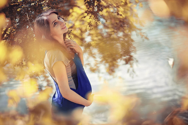 Mujer embarazada en un paseo por el parque en otoño
 - Foto, Imagen