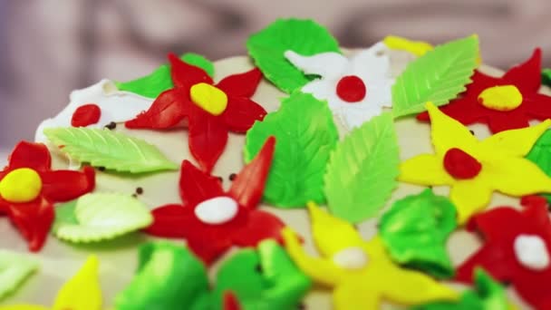 Pastel de dos pisos decorado con pequeñas flores artificiales en forma de estrella de colores
 - Metraje, vídeo