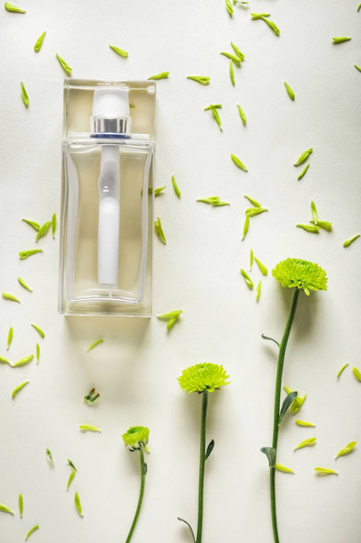 Transparent bottle of perfume with beautiful flowers on light background - Photo, Image