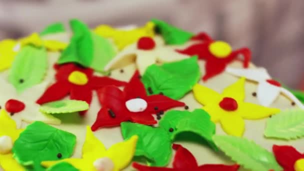 Rotující dvoupatrový dort zdobený malými barevnými hvězda ve tvaru květiny - Záběry, video