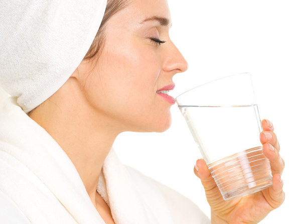 Young woman in bathrobe drinking pure water - Fotoğraf, Görsel