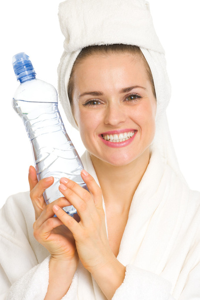 Young woman in bathrobe with water bottle - 写真・画像