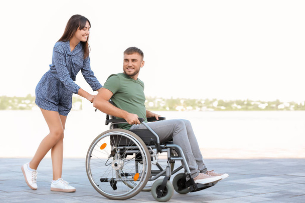 Ευτυχισμένος νέος σε αναπηρική καρέκλα και η σύζυγός του έξω - Φωτογραφία, εικόνα