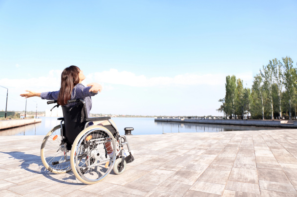 Açık havada tekerlekli sandalyede mutlu genç kadın - Fotoğraf, Görsel