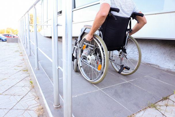 Jeune homme en fauteuil roulant sur la rampe à l'extérieur - Photo, image