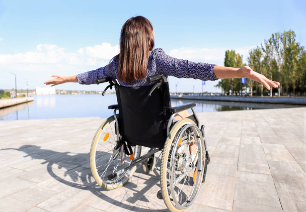 Joyeux jeune femme en fauteuil roulant à l'extérieur
 - Photo, image