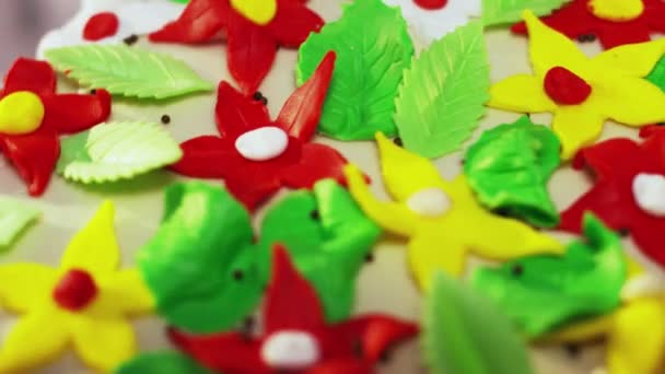 Roterende dubbele decker taart gedecoreerd met kleine kleurrijke ster vormige bloemen - Video