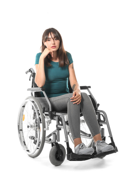 Nuori nainen pyörätuolissa valkoisella taustalla
 - Valokuva, kuva