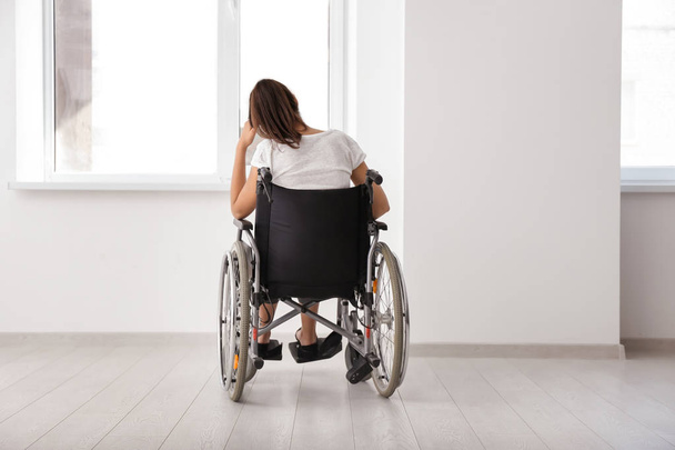 Depressed handicapped woman in empty room - Foto, Imagen