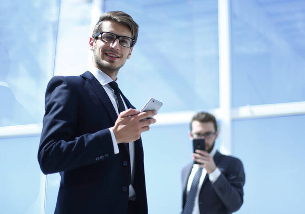 modern üzletember egy smartphone, irodai háttér - Fotó, kép